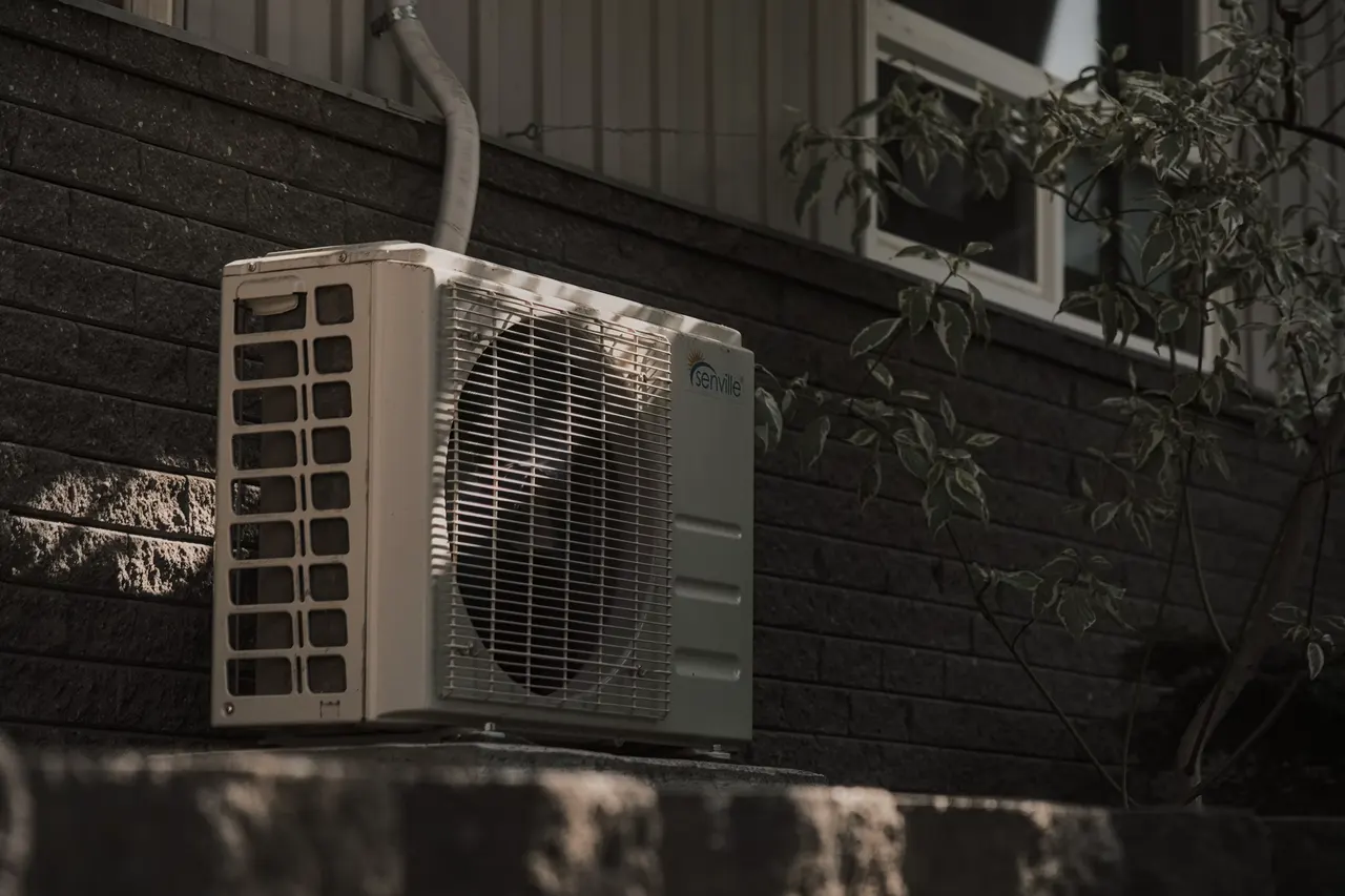 Groupe extérieur d’une pompe à chaleur air/air installé contre un mur en brique