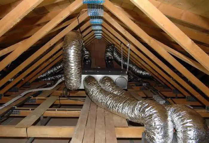 Réseau de gaines isolées d’une climatisation gainable installé dans des combles